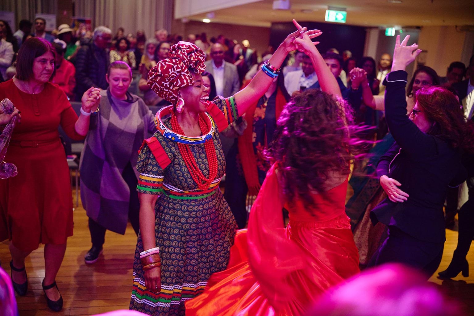 Guests from multicultural backgrounds dance the tarantella together.